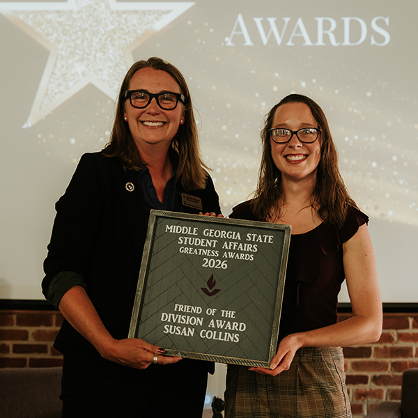 Dr. Jennifer Brannon and award recipient Susan Collins smile while holding a plaque that reads, "Middle Georgia State Student Affairs Greatness Awards 2026 - Friend of the Division Award, Susan Collins."